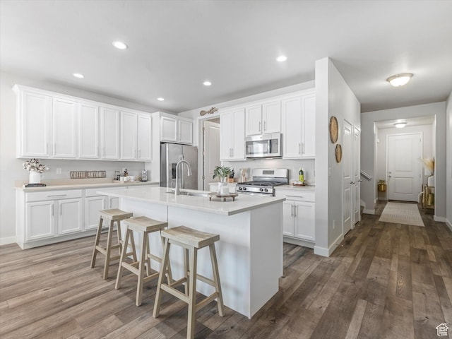 6612 W Terrace Wash Ln S Unit 119, West Jordan, UT 84081 - kitchen with stainless steel appliances, light countertops, white cabinetry, an island with sink, and recessed lighting