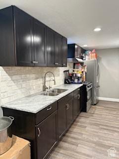 3035 Brinker Ave, Ogden, UT 84403 - kitchen featuring light wood finished floors, light countertops, tasteful backsplash, extractor fan, and recessed lighting