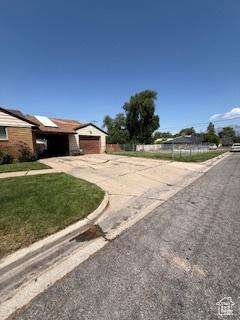3035 Brinker Ave, Ogden, UT 84403 - view of front of house featuring concrete driveway, an attached garage, and a front lawn