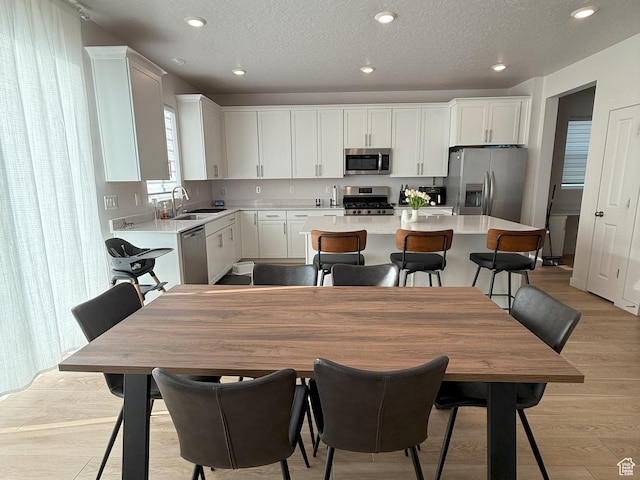 2563 N Velvet Moon Dr W Unit 625, Saratoga Springs, UT 84045 - kitchen featuring appliances with stainless steel finishes, a kitchen island, light countertops, white cabinetry, and light wood-style floors