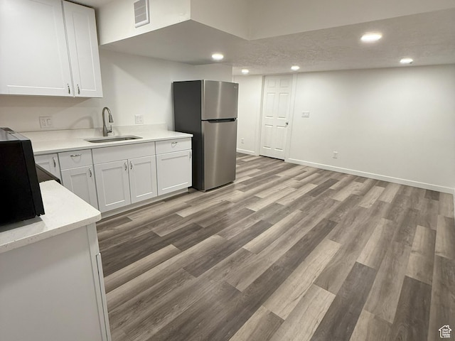 2563 N Velvet Moon Dr W Unit 625, Saratoga Springs, UT 84045 - kitchen with freestanding refrigerator, white cabinets, recessed lighting, light wood-style floors, and light stone countertops