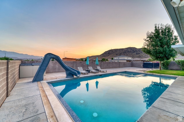 3410 W 2490 S, Hurricane, UT 84737 - view of pool with a water slide, a mountain view, a fenced backyard, a patio area, and a pool with connected hot tub