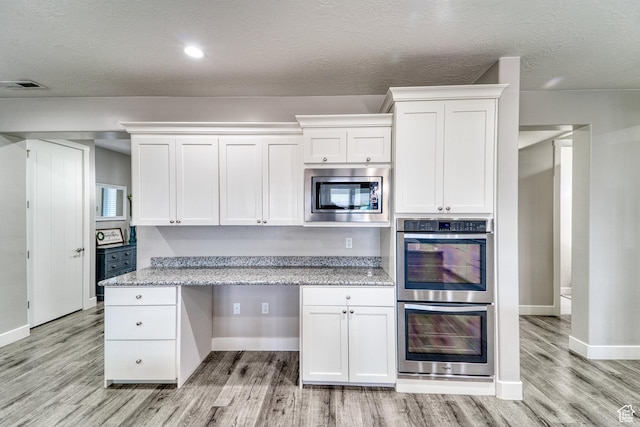 3410 W 2490 S, Hurricane, UT 84737 - kitchen with appliances with stainless steel finishes, light wood-type flooring, white cabinetry, light stone counters, and a textured ceiling