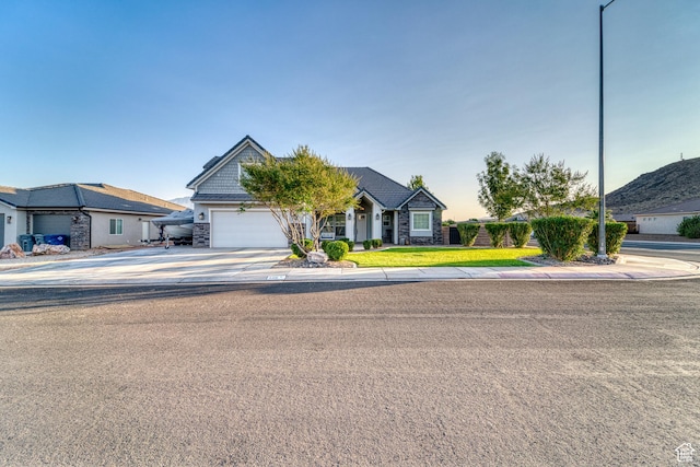 3410 W 2490 S, Hurricane, UT 84737 - view of front of house featuring driveway, an attached garage, stone siding, and a front yard