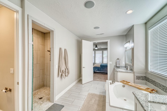 3410 W 2490 S, Hurricane, UT 84737 - full bathroom featuring vanity, a garden tub, tiled shower, a ceiling fan, and a textured ceiling