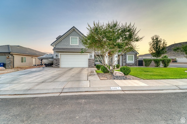 3410 W 2490 S, Hurricane, UT 84737 - view of front of property featuring stone siding, driveway, a front yard, and a garage