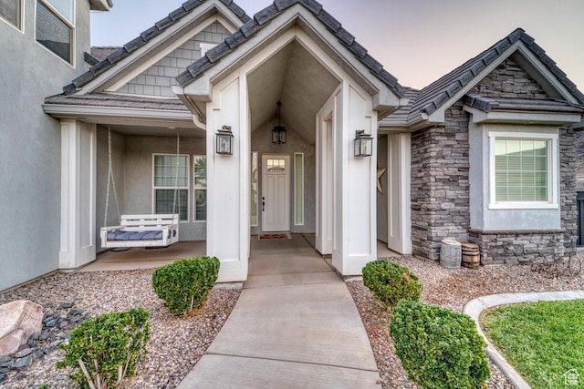 3410 W 2490 S, Hurricane, UT 84737 - doorway to property featuring stone siding, stucco siding, and a porch