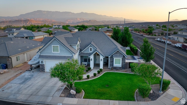 3410 W 2490 S, Hurricane, UT 84737 - view of front of house with stone siding, a mountain view, a residential view, and concrete driveway