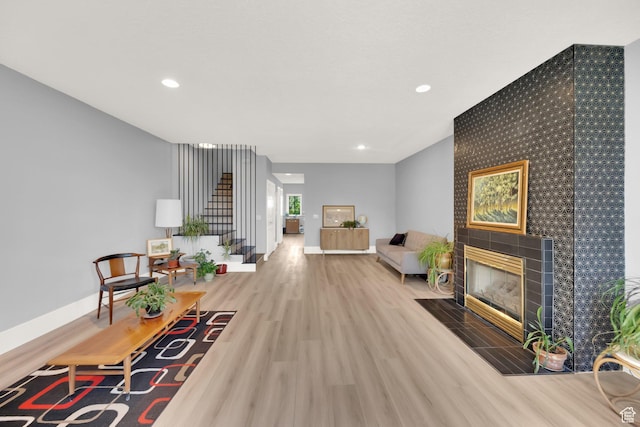 468 N E St, Salt Lake City, UT 84103 - living area with stairway, wood finished floors, recessed lighting, a tiled fireplace, and an accent wall