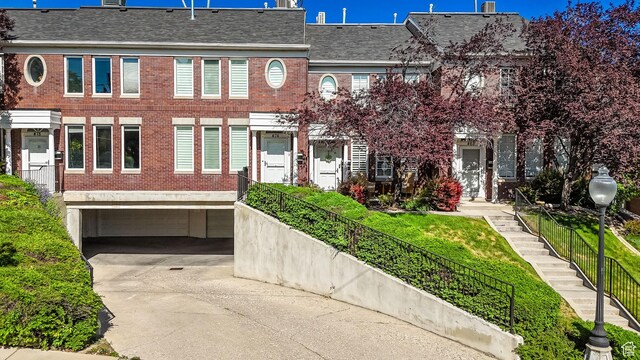 468 N E St, Salt Lake City, UT 84103 - view of property featuring brick siding, driveway, and an attached garage