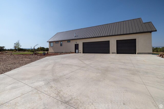 10371 N 400 W, Roosevelt, UT 84066 - view of property exterior with a metal roof, concrete driveway, stucco siding, and a standing seam roof