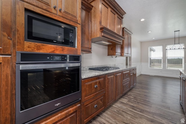 10371 N 400 W, Roosevelt, UT 84066 - kitchen with stainless steel appliances, dark wood finished floors, wainscoting, light stone counters, and decorative light fixtures