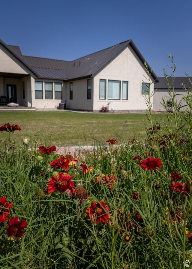10371 N 400 W, Roosevelt, UT 84066 - rear view of property featuring a metal roof, stucco siding, and a yard