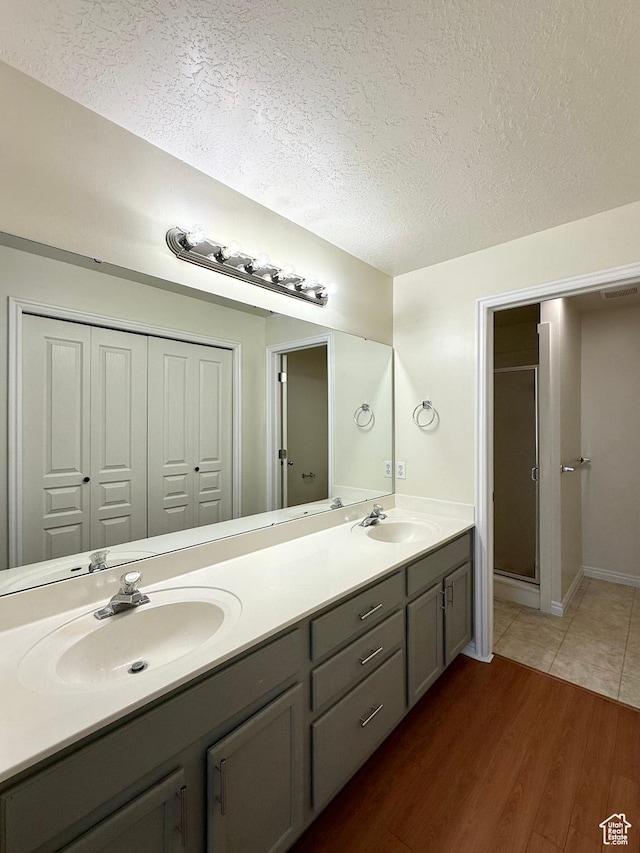2421 N 400 E Unit E7, North Ogden, UT 84414 - full bath with double vanity, a textured ceiling, wood finished floors, and a stall shower