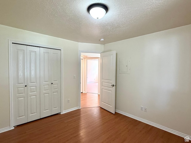 2421 N 400 E Unit E7, North Ogden, UT 84414 - unfurnished bedroom with wood finished floors, a textured ceiling, a closet, and electric panel