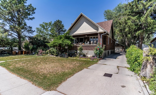 550 S Cheyenne St W, Salt Lake City, UT 84104 - view of front of property with a front yard, brick siding, and covered porch
