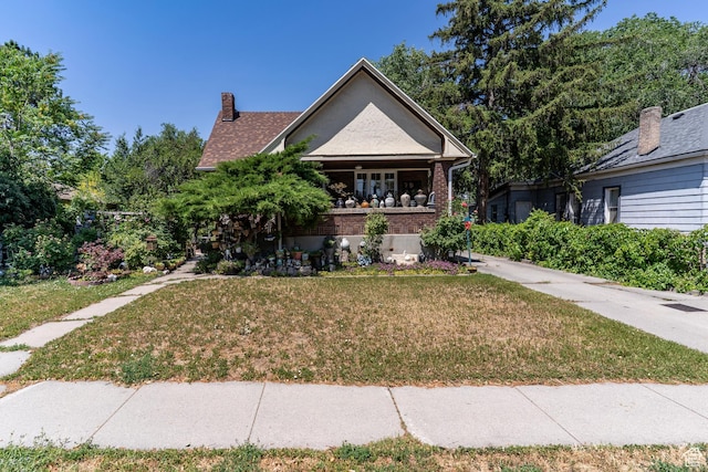 550 S Cheyenne St W, Salt Lake City, UT 84104 - view of front facade with a front yard, brick siding, and a chimney