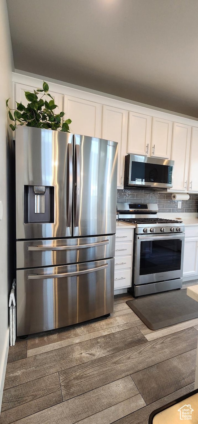 5332 W Scout Plane Ln, South Jordan, UT 84009 - kitchen with appliances with stainless steel finishes, white cabinets, and decorative backsplash