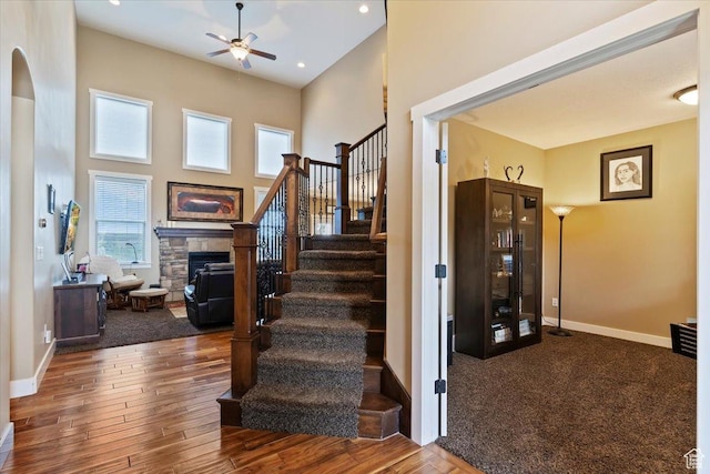 469 W 5700 S, Washington Terrace, UT 84405 - staircase featuring ceiling fan, a stone fireplace, a towering ceiling, wood finished floors, and recessed lighting