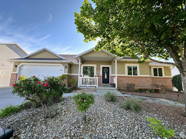 8675 S Pebblecreek Rd, West Jordan, UT 84081 - view of front facade featuring stucco siding, a garage, brick siding, and driveway