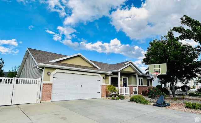 8675 S Pebblecreek Rd, West Jordan, UT 84081 - view of front of home with brick siding, an attached garage, driveway, covered porch, and roof with shingles