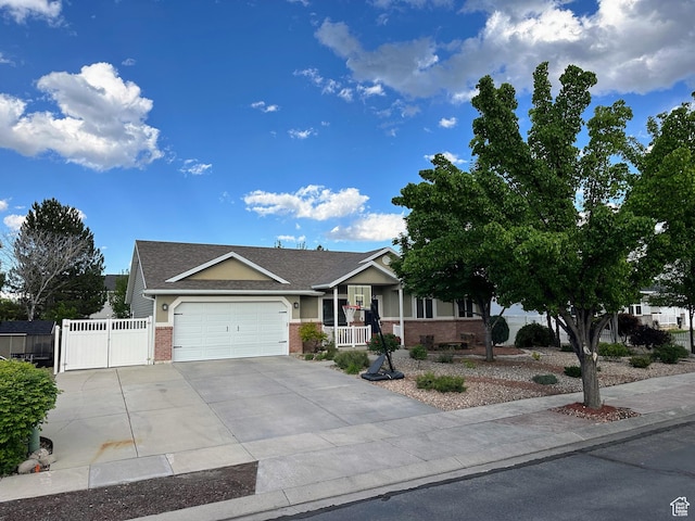 8675 S Pebblecreek Rd, West Jordan, UT 84081 - view of front of home featuring brick siding, an attached garage, driveway, a gate, and a porch