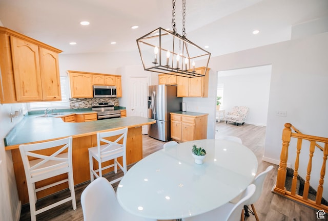 9961 N 4680 W, Cedar Hills, UT 84062 - kitchen featuring stainless steel appliances, light brown cabinets, a peninsula, a chandelier, and lofted ceiling