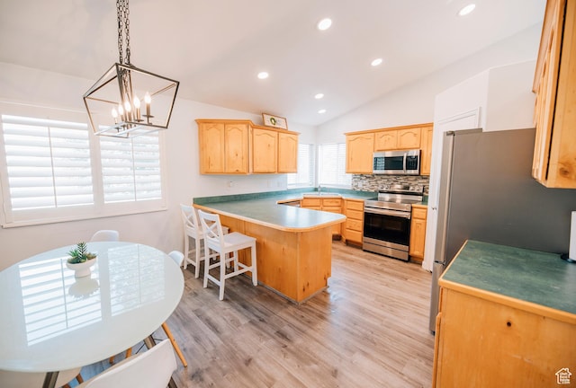 9961 N 4680 W, Cedar Hills, UT 84062 - kitchen with stainless steel appliances, light brown cabinets, a peninsula, vaulted ceiling, and a chandelier