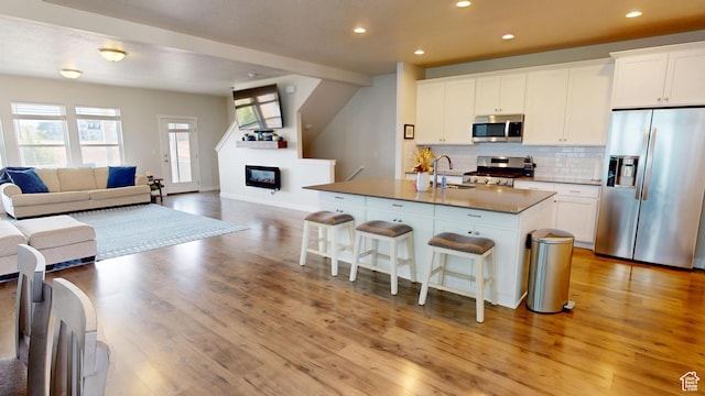 11393 S Prosperity Rd W, South Jordan, UT 84009 - kitchen with stainless steel appliances, a breakfast bar area, open floor plan, light wood-style floors, and recessed lighting