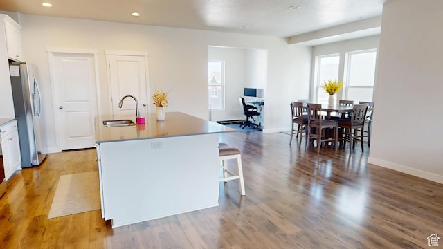 11393 S Prosperity Rd W, South Jordan, UT 84009 - kitchen with freestanding refrigerator, an island with sink, white cabinetry, light wood finished floors, and recessed lighting