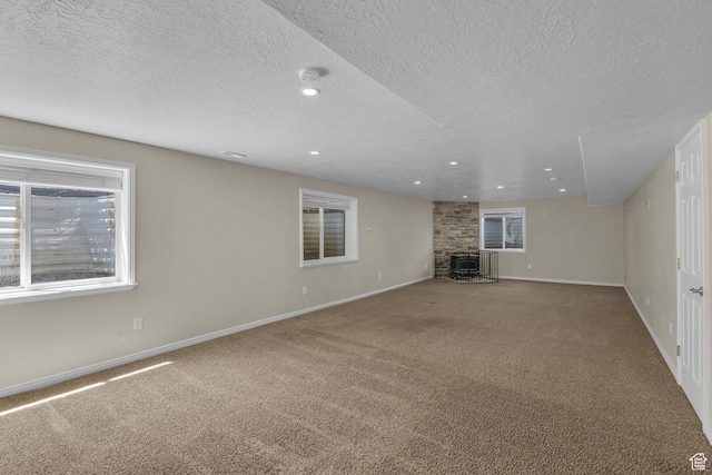 4301 N Majors St E, Eagle Mountain, UT 84005 - unfurnished living room with a textured ceiling, carpet floors, a fireplace, and recessed lighting