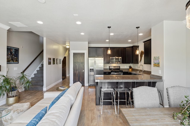 1348 Fiddich Glen Ln, Park City, UT 84098 - kitchen with stainless steel appliances, light wood-style floors, a breakfast bar, a peninsula, and recessed lighting