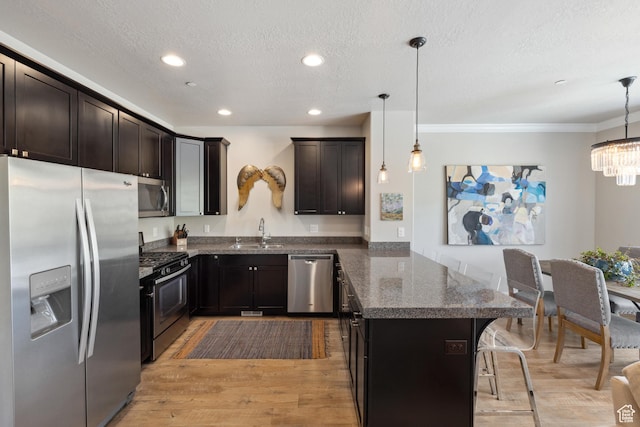 1348 Fiddich Glen Ln, Park City, UT 84098 - kitchen featuring appliances with stainless steel finishes, a peninsula, ornamental molding, a kitchen bar, and dark stone counters
