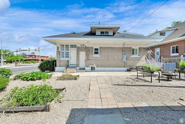 1203 25th St, Ogden, UT 84401 - rear view of property featuring brick siding, a garden, a fire pit, and a patio