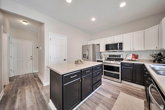 5961 W Chiswick Ct, West Jordan, UT 84081 - kitchen featuring stainless steel appliances, dark cabinetry, white cabinetry, light countertops, and recessed lighting