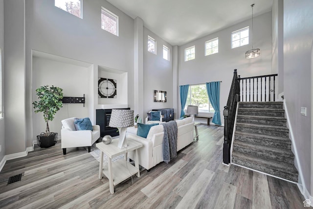 5961 W Chiswick Ct, West Jordan, UT 84081 - living room featuring a towering ceiling, wood finished floors, plenty of natural light, and stairs