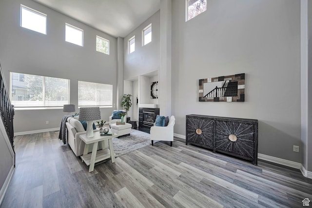 5961 W Chiswick Ct, West Jordan, UT 84081 - living area featuring wood finished floors, a glass covered fireplace, and a towering ceiling