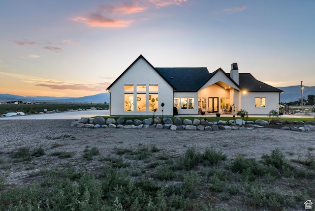 1952 N Sr 118, Monroe, UT 84754 - back of property at dusk with stucco siding, a chimney, and roof with shingles