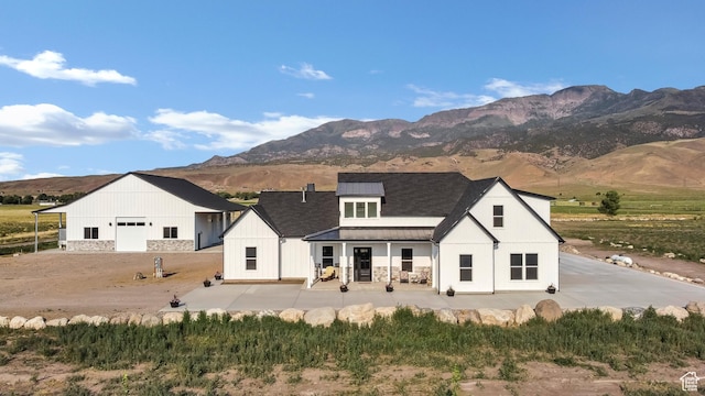 1952 N Sr 118, Monroe, UT 84754 - back of house with a standing seam roof, roof with shingles, a metal roof, a mountain view, and a patio