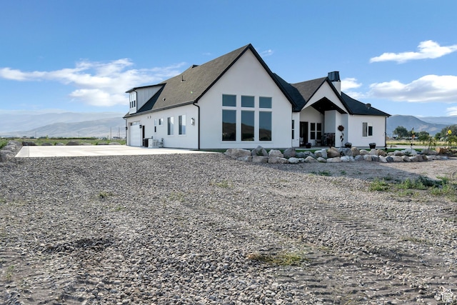 1952 N Sr 118, Monroe, UT 84754 - back of house with a mountain view, a chimney, a garage, driveway, and stucco siding