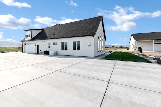 1952 N Sr 118, Monroe, UT 84754 - view of front of house featuring driveway, a shingled roof, a front yard, stucco siding, and an attached garage