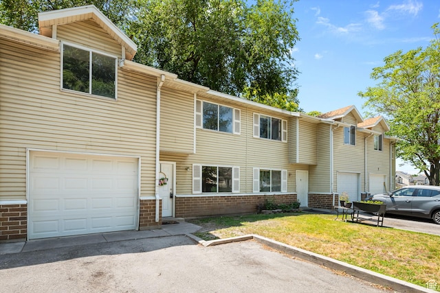 558 N Redwood Rd Unit 3, Salt Lake City, UT 84116 - view of property with brick siding, an attached garage, and a front yard