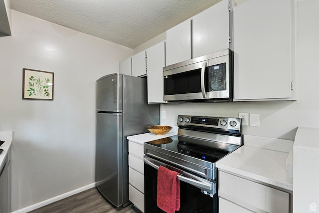 558 N Redwood Rd Unit 3, Salt Lake City, UT 84116 - kitchen featuring appliances with stainless steel finishes, dark wood-type flooring, and a textured ceiling
