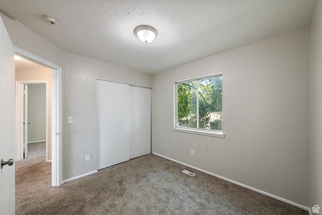 558 N Redwood Rd Unit 3, Salt Lake City, UT 84116 - unfurnished bedroom featuring carpet floors, a closet, and a textured ceiling