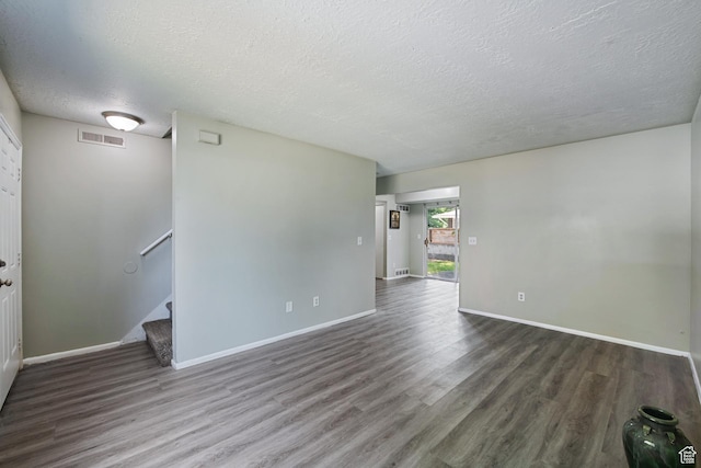 558 N Redwood Rd Unit 3, Salt Lake City, UT 84116 - empty room featuring wood finished floors, a textured ceiling, and stairway
