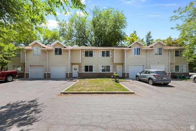 558 N Redwood Rd Unit 3, Salt Lake City, UT 84116 - multi unit property with an attached garage, driveway, brick siding, and a front lawn