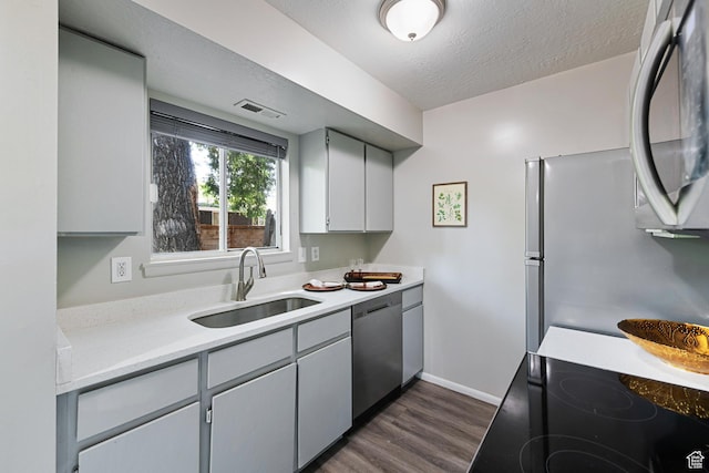558 N Redwood Rd Unit 3, Salt Lake City, UT 84116 - kitchen featuring stainless steel appliances, dark wood-style flooring, light countertops, gray cabinets, and a textured ceiling