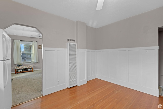 330 N 100 W, Brigham City, UT 84302 - empty room with a heating unit, light wood-type flooring, a decorative wall, a wainscoted wall, and ceiling fan