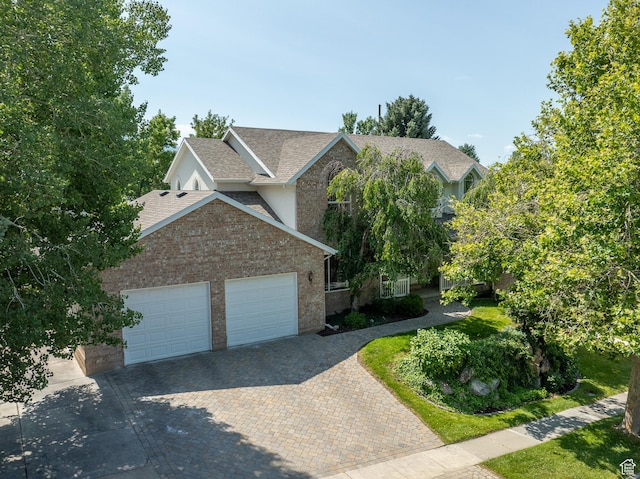 1320 E Canberra Dr, Lindon, UT 84042 - view of front of home featuring a garage, decorative driveway, roof with shingles, and brick siding