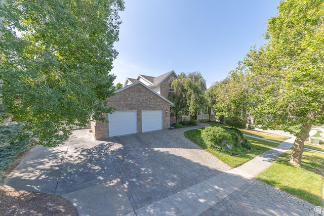 1320 E Canberra Dr, Lindon, UT 84042 - view of front facade featuring driveway, brick siding, an attached garage, and a front yard